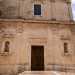La facciata del luogo di culto, in stile classico,  scandita da tre livelli...